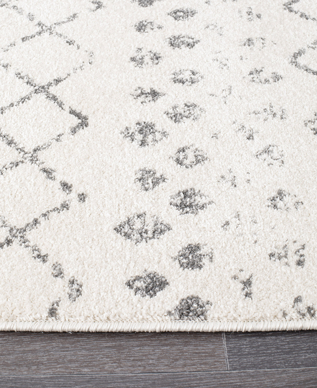 Up close, one of the rug's tightly bound edges and the low-pile texture is the focus.