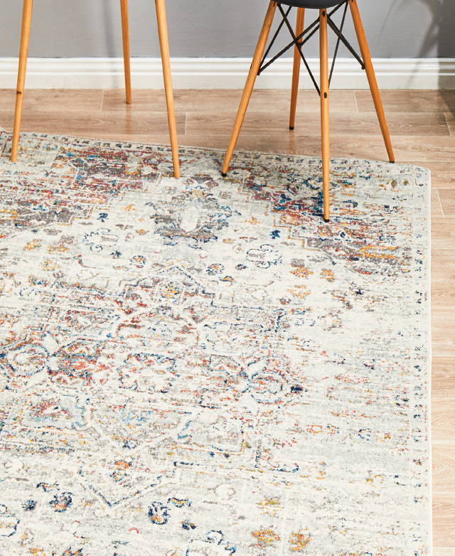 A rug with a vintage-inspired pattern is styled on top of a timber floor and underneath the legs of surrounding furniture.