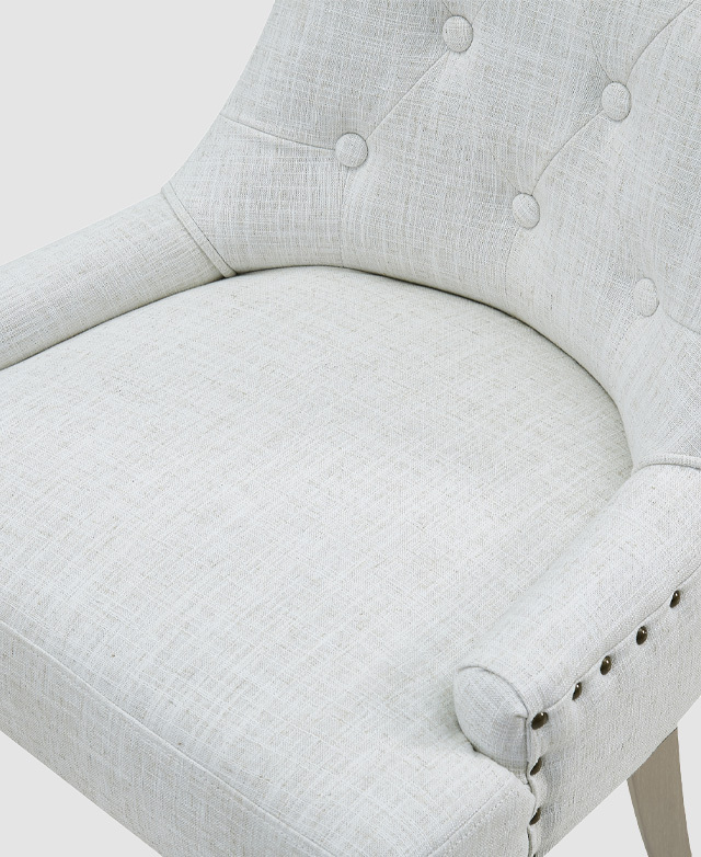 Bird's-eye view of the scooped seat of chair with ivory upholstery, depicting its spacious depth and curved backrest. Bird's-eye view of the scooped seat of chair with ivory upholstery, depicting its spacious depth and curved backrest.