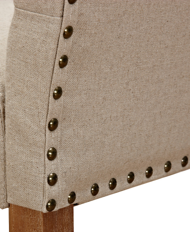 The smooth metal studs that line the back edges of the stool are shown close up from one corner.