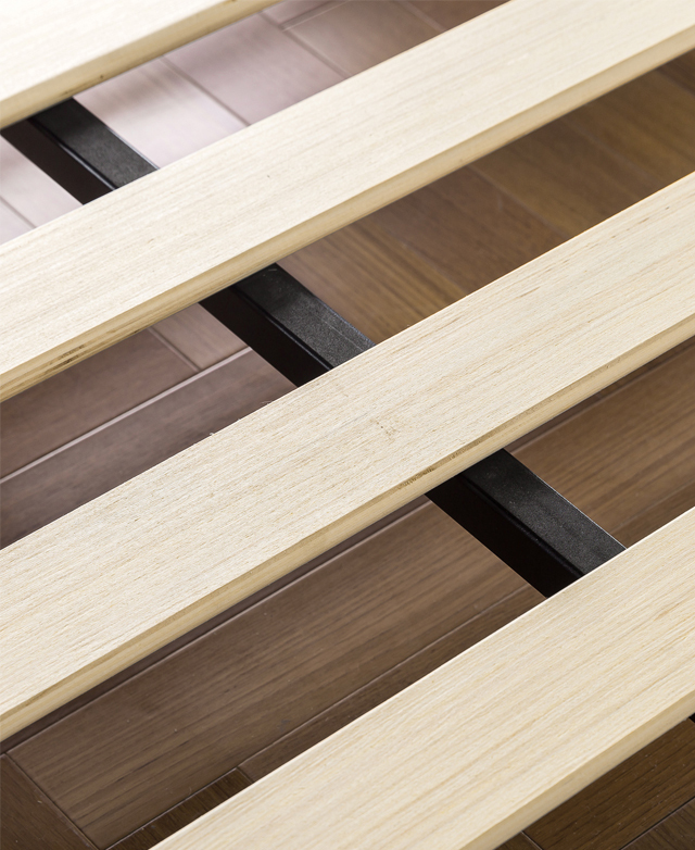 Blonde plywood slats bisect the black, steel central support bar.