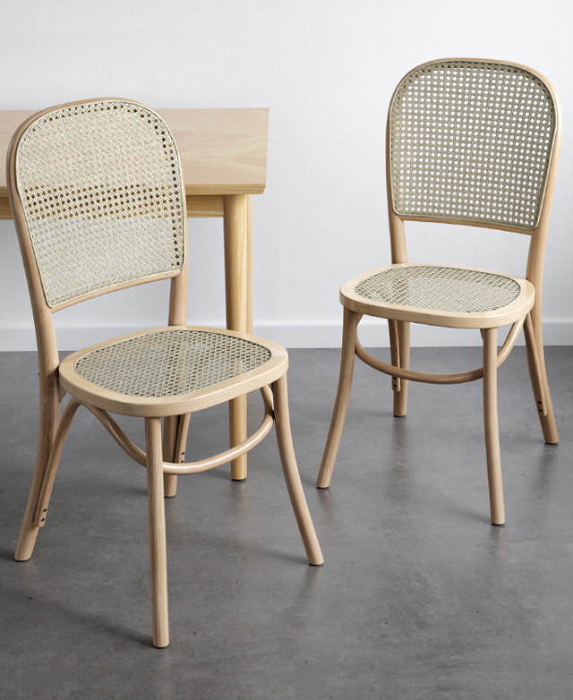 A pair of chairs are angled inwards next to a bare table, displaying bentwood elements.