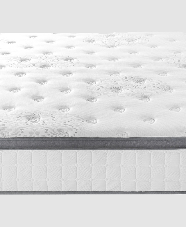 From the side, a close-up of the mattress displays grey trims and a soft grey pattern on the white top.
