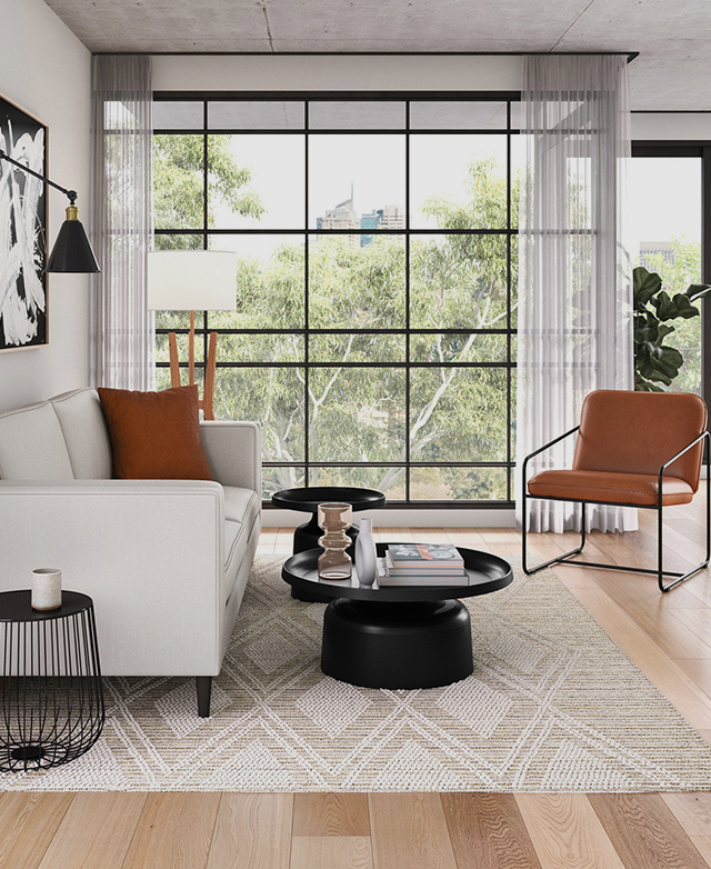 A large black panelled window frames the living room, which is set up with sofa, chairs, a rug, and coffee and side tables. A large black panelled window frames the living room, which is set up with sofa, chairs, a rug, and coffee and side tables.