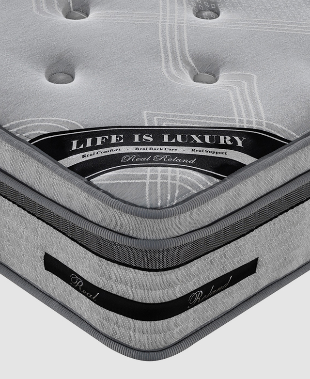 The corner of a mattress is shown. It has a 5 zone pocket spring base layer and a memory foam top layer.