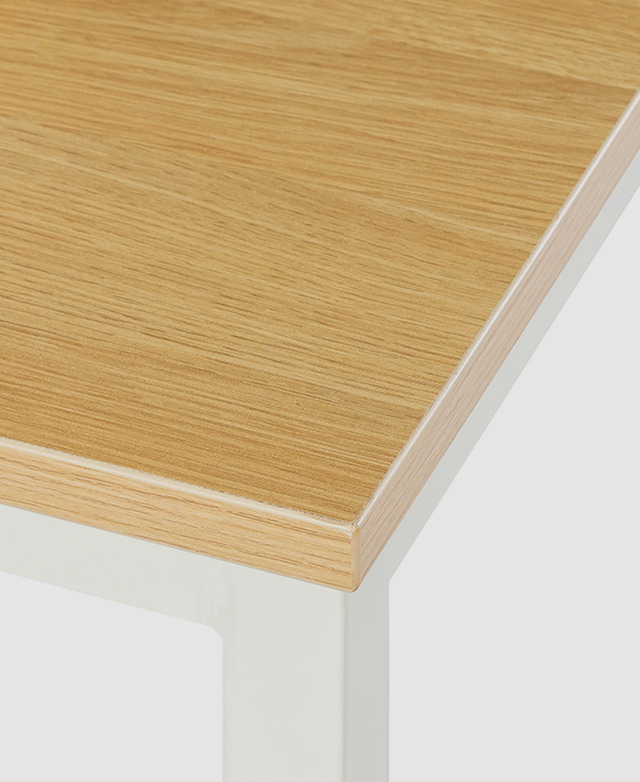 A corner view of the table top highlights its smooth edges and the wood-look grain of the melamine veneer. A corner view of the table top highlights its smooth edges and the wood-look grain of the melamine veneer.