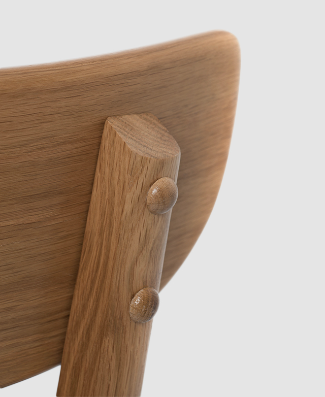 The posterior of the backrest displays the directional grain of oak wood, with beautiful timber joinery.