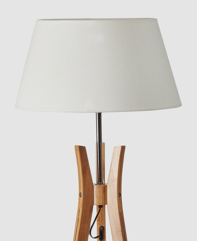 The lamp shade in a classic empire shape, wrapped in white linen for a soft and cosy diffusion of light.