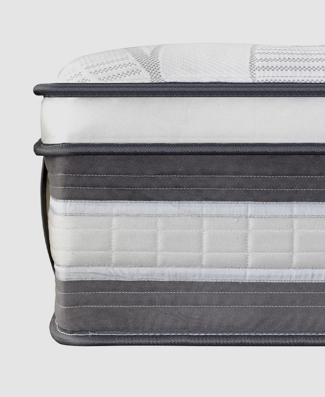 Side view of a knitted mattress with multiple layers of support and a thick grey piping trim around the edge.
