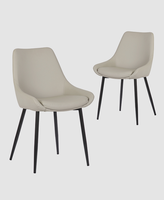 Two cream faux leather dining chairs with a tub-like seat and black powder-coated legs.