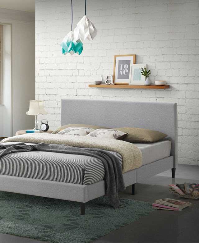 A comfy bedroom setting, with fanned magazines on the ground, & a green rug at the foot. The bed is dressed in cosy layers. A comfy bedroom setting, with fanned magazines on the ground, & a green rug at the foot. The bed is dressed in cosy layers.