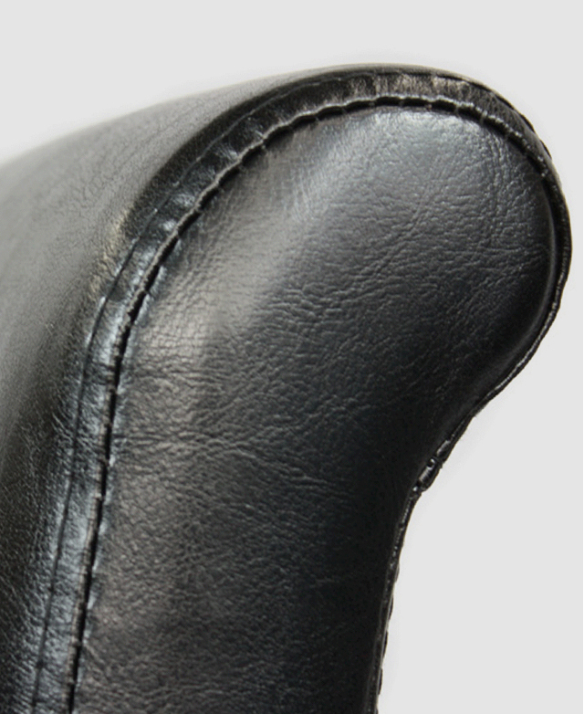 Close up of a chair's tall backrest, which has a slightly rolled edge at the top. Close up of a chair's tall backrest, which has a slightly rolled edge at the top.