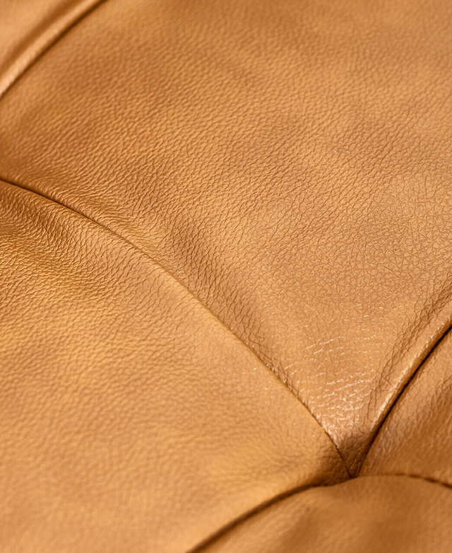 The image is zoomed in on the faux leather, which shows subtle pleating and a pebbled texture.