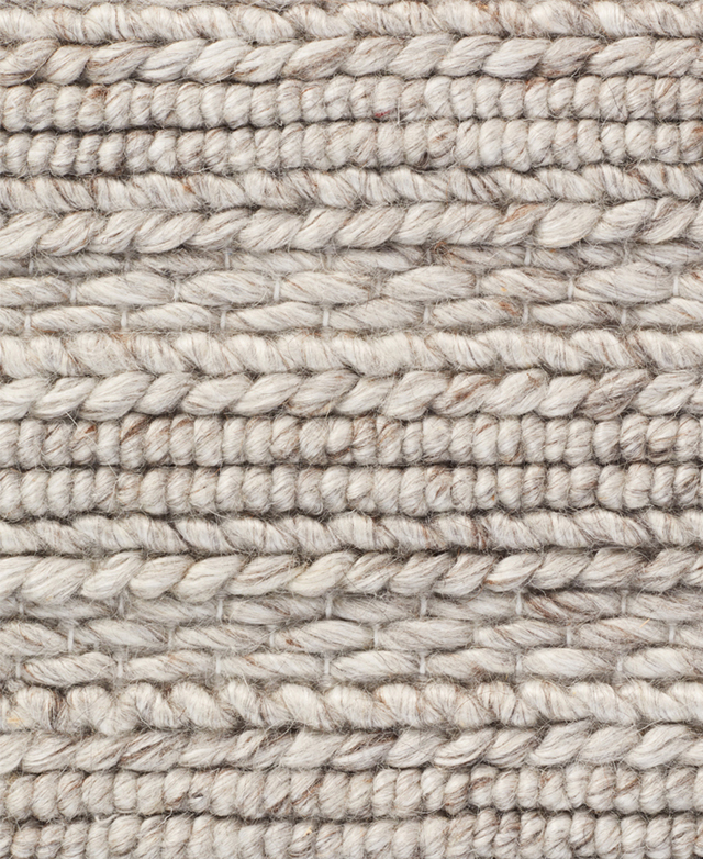Large-scale view of the chunky hand woven texture of a grey wool rug.