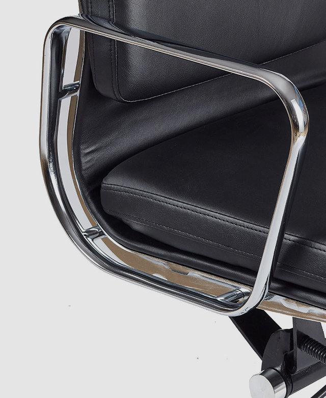 The three-quarter angle zooms in on the real leather upholstery through the hollow, polished metal armrest.