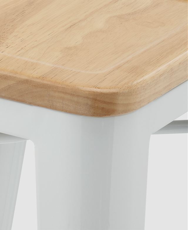 A corner of the bar stool's rubberwood timber seat is in focus. It is gently curved, giving it a smoother look and feel.