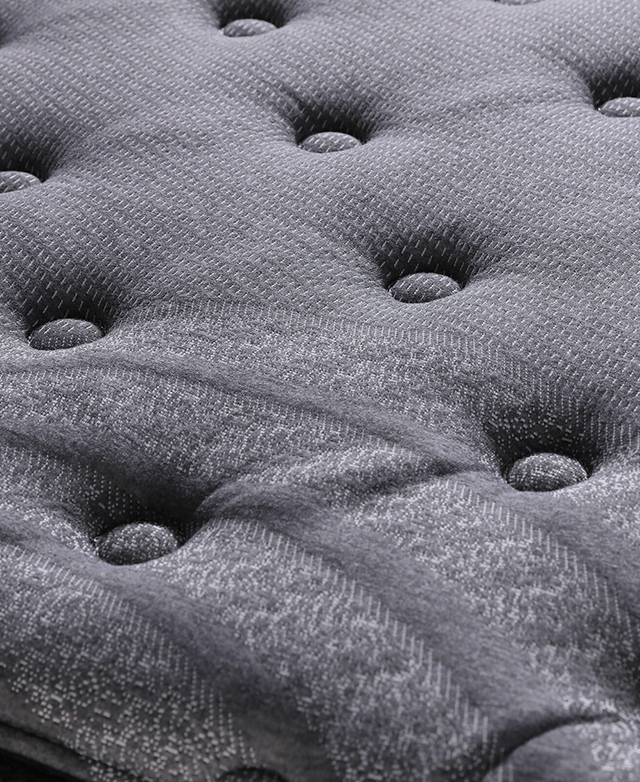 A close-up shot of the charcoal-coloured knitted fabric on the top, complete with button tufting.