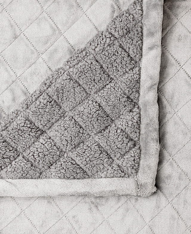 A bird's eye view of the blanket displays it turned back at one corner so both the velvet and the sherpa sides are shown. A bird's eye view of the blanket displays it turned back at one corner so both the velvet and the sherpa sides are shown.