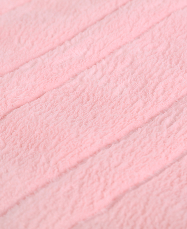 The fluffy texture of a polyester coral fleece blanket in a soft pink colour is shown. The fluffy texture of a polyester coral fleece blanket in a soft pink colour is shown.