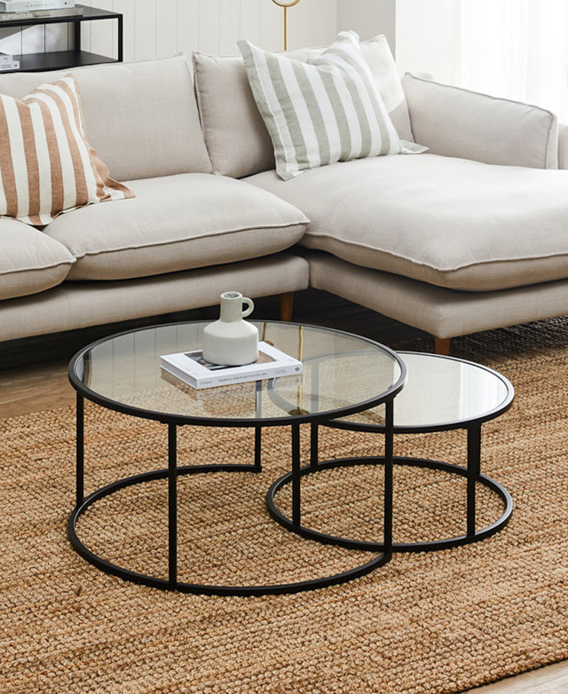The tables are styled together on top of a warm, jute rug in a light room, near a creamy-grey chaise sofa. The tables are styled together on top of a warm, jute rug in a light room, near a creamy-grey chaise sofa.