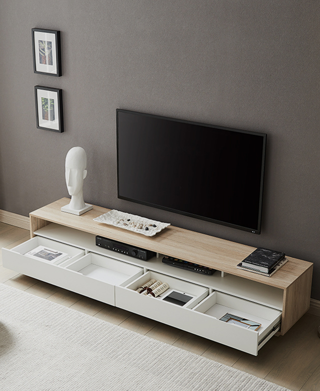 A bird's eye view allows us to identify four open drawers containing household items, a TV on top, and artwork on the wall.