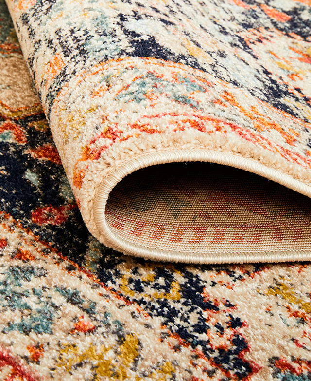 The magnified rug is folded back on itself. The low pile and bound edges are in focus.
