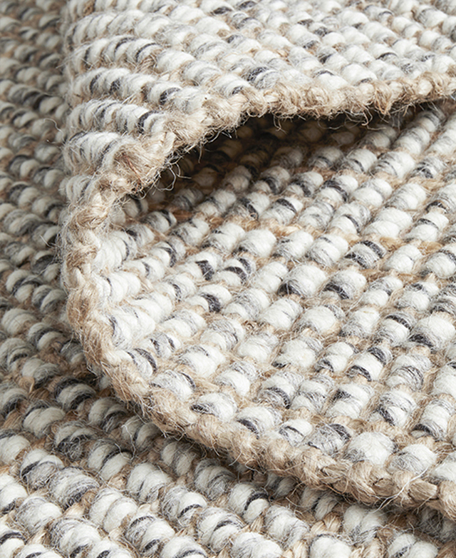The rug is zoomed in on to highlight the fibres and the textures. It's folded back to display identical sides.