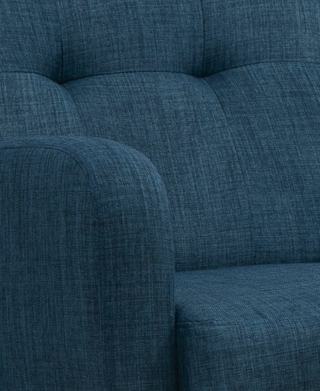 The thick, padded armrest of the upholstered chair is in focus. The thick, padded armrest of the upholstered chair is in focus.