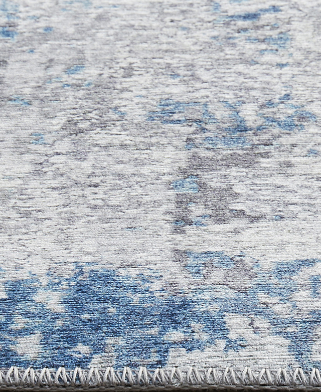 A blue and grey floor rug with an abstract pattern and thick woven edge.