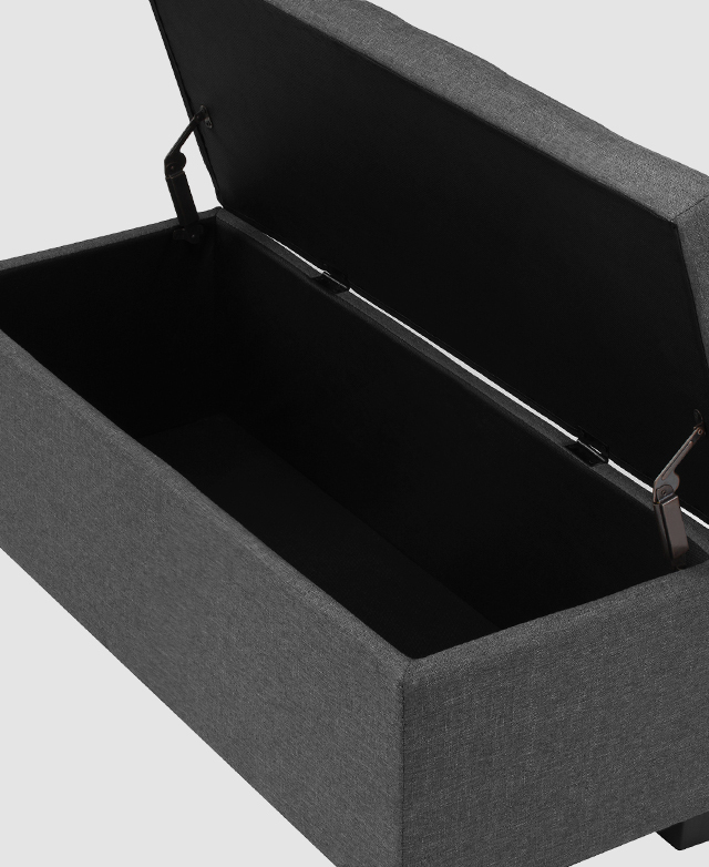 The charcoal ottoman's lid is lifted, so a generous, dark space is revealed.