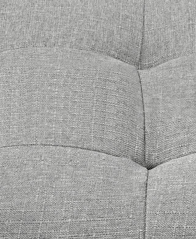 The slub-like upholstery texture of the light grey ottoman is depicted close-up.