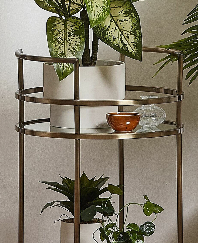For a natural look, vibrant plants are styled on the bar cart's top and bottom shelves. For a natural look, vibrant plants are styled on the bar cart's top and bottom shelves.