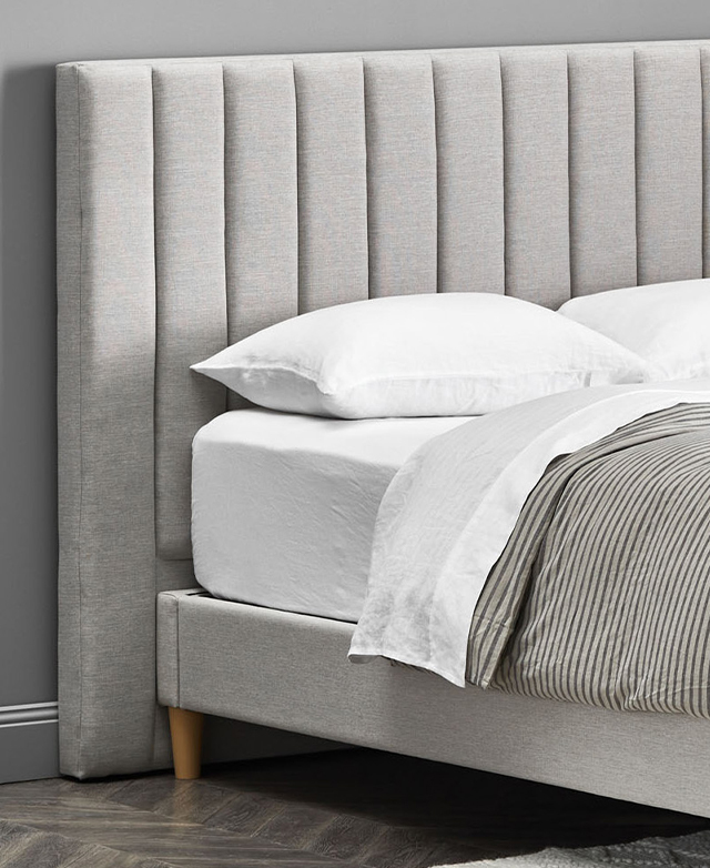 White and grey striped bedding adorns the bed, which has been paired with a grey upholstered, channel stitched bedhead. White and grey striped bedding adorns the bed, which has been paired with a grey upholstered, channel stitched bedhead.