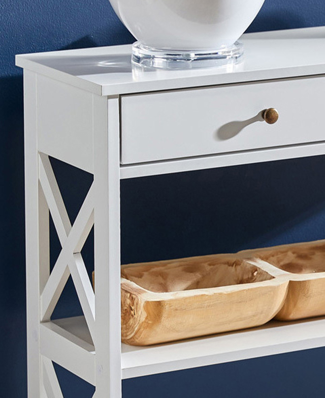One corner of the console table showing an overhanging top and cross accents on the side. One corner of the console table showing an overhanging top and cross accents on the side.