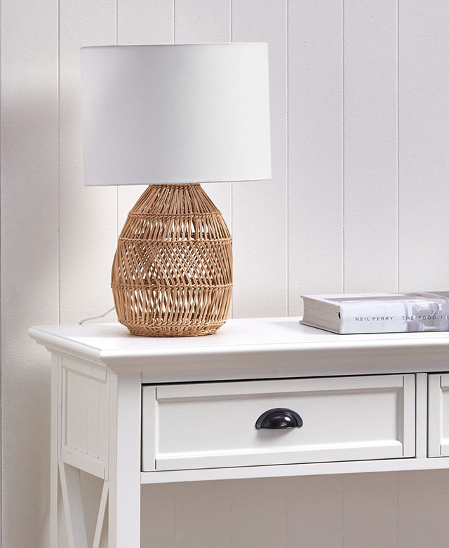 The panelling around the edges of one of the drawers, and on one end is on display. A rattan lamp and a book sits on top. The panelling around the edges of one of the drawers, and on one end is on display. A rattan lamp and a book sits on top.