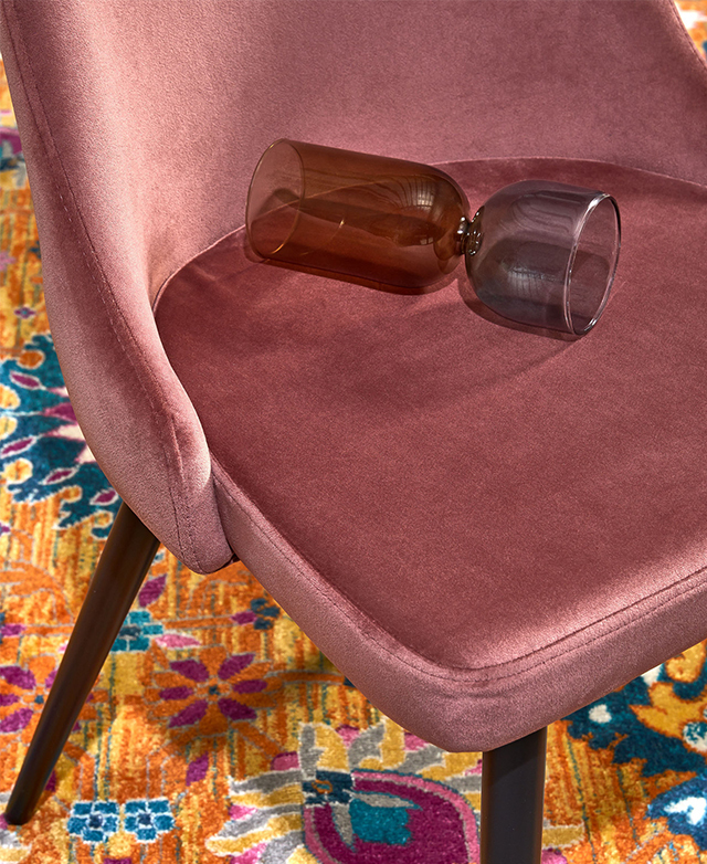 Bird's-eye view of a pink velvet dining chair, with an art deco glass on the seat cushion for a stylish touch.