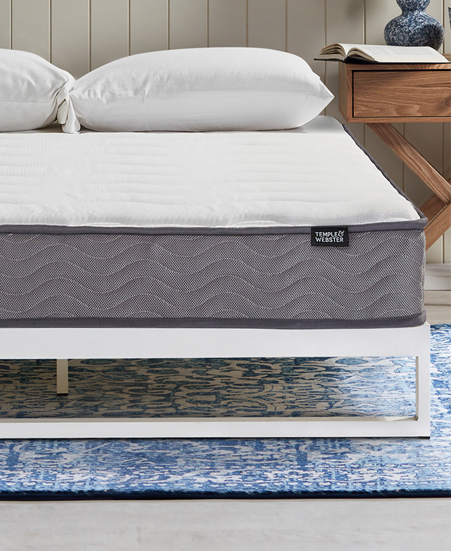 Displayed from a front-facing position, the bed is topped with a T&W mattress, and stands on a blue patterned rug.