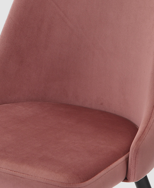 Large-scale view of a dining chair's velvet pink upholstery.