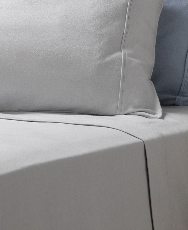 Plump pillows are styled atop a bed dressed in silver brushed cotton flannelette sheets. Plump pillows are styled atop a bed dressed in silver brushed cotton flannelette sheets.