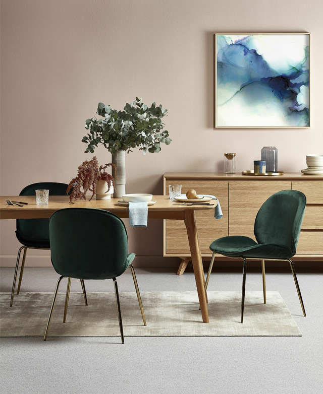 The dining table is in situ in a contemporary space alongside abstract artwork, velvet dining chairs, and golden accents. The dining table is in situ in a contemporary space alongside abstract artwork, velvet dining chairs, and golden accents.