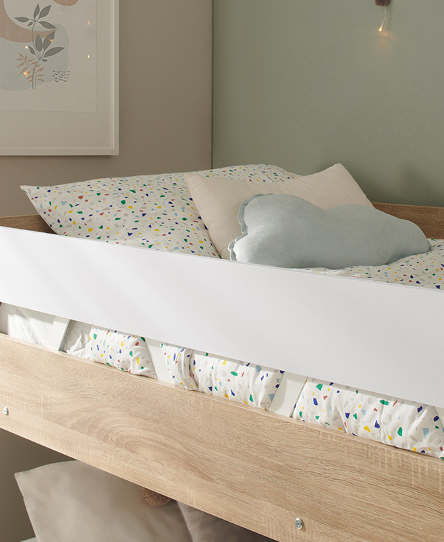 Colourful terrazzo patterned bedding and a cloud-shaped blue cushion is arranged on the top bunk. Colourful terrazzo patterned bedding and a cloud-shaped blue cushion is arranged on the top bunk.
