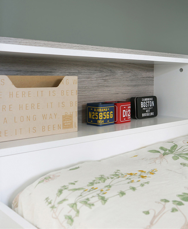 A few decor items are stored on the integrated shelf units behind the bunk bed mattresses.