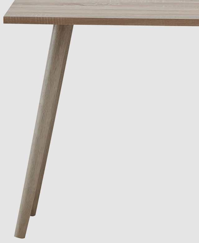 The rubberwood legs underneath a light blonde timber office desk have a tapered shape and are splayed for stability.