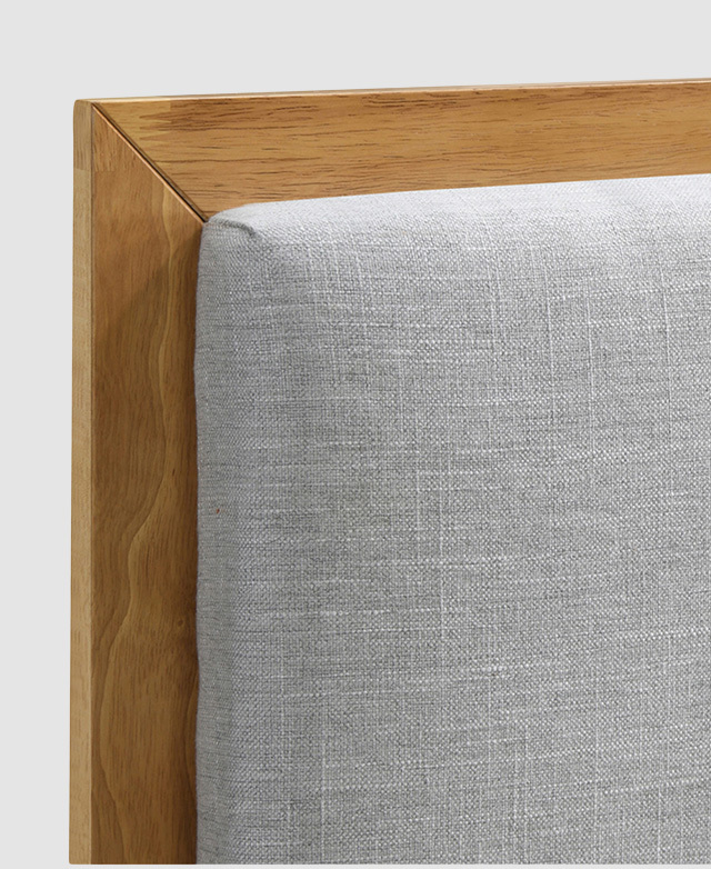 Close-up of one corner of the bedhead displays the solid rubberwood frame around the perimeter of the padded fabric. Close-up of one corner of the bedhead displays the solid rubberwood frame around the perimeter of the padded fabric.
