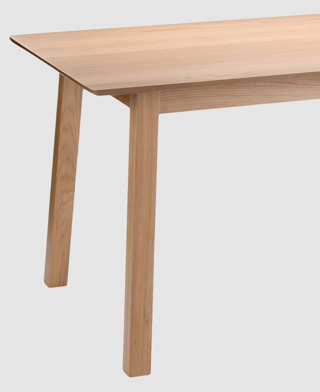 The cropped image conveys the table's smooth oak veneer finish in detail. The rounded corners are clearly displayed. The cropped image conveys the table's smooth oak veneer finish in detail. The rounded corners are clearly displayed.