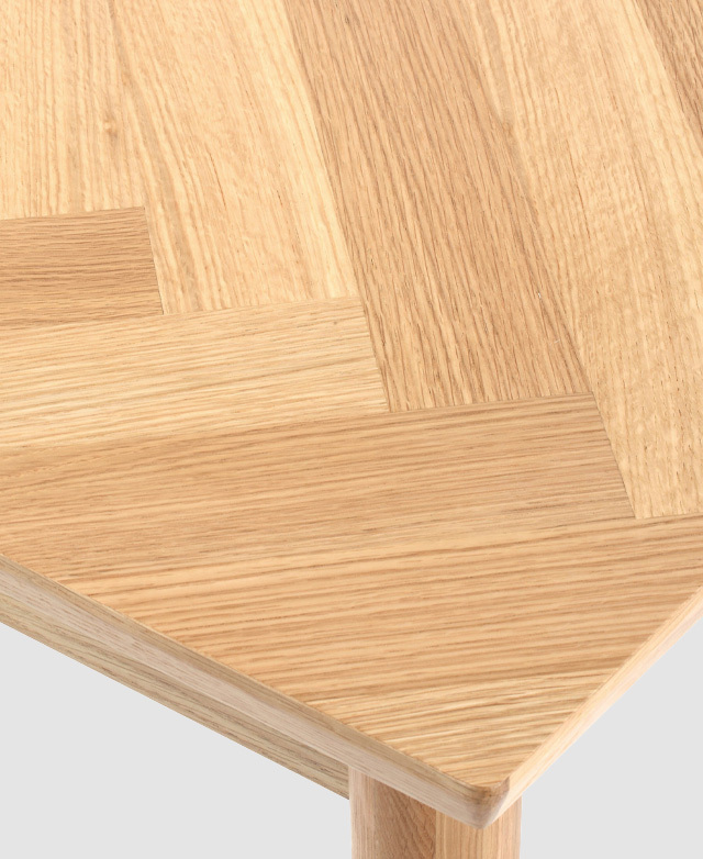 Bird's-eye view of the herringbone pattern that adorns the oak veneer finish on the desk's table top.