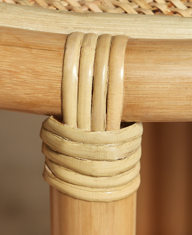 Close-up of woven rattan strands joining the seat to the base, reinforcing its strength.