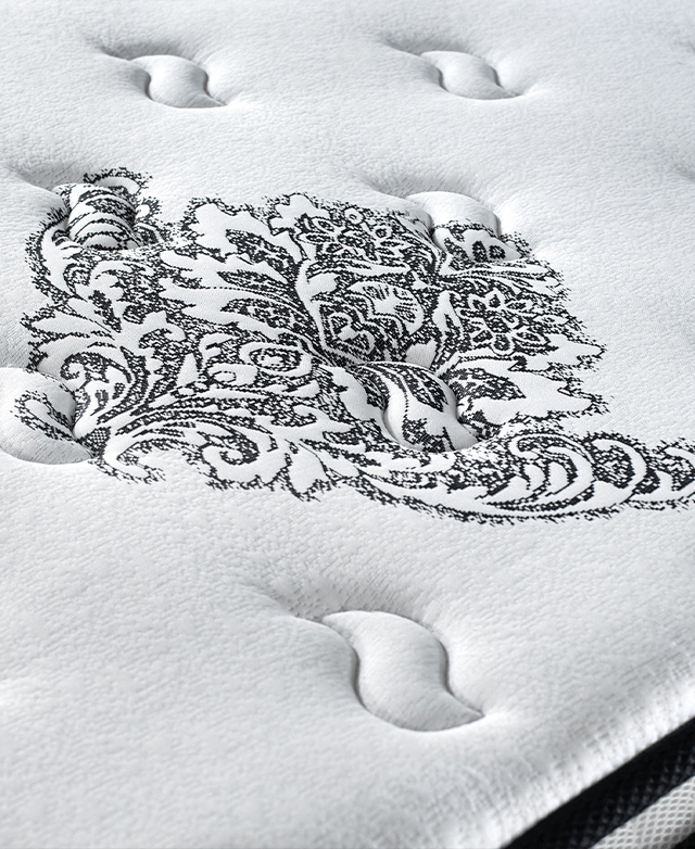 The top of the mattress is shown, with tufted embroidery stitched into the premium fabric.