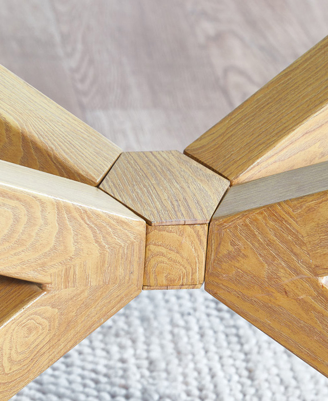 The timber joinery in the middle of the base of a table connects the angular steel legs. It has an oak look finish. The timber joinery in the middle of the base of a table connects the angular steel legs. It has an oak look finish.