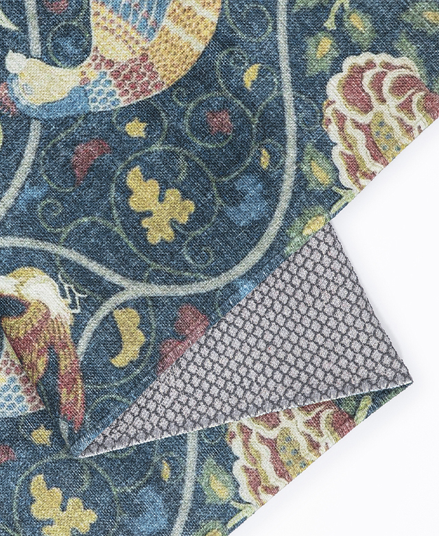 The ornately patterned rug is shown folded over on itself, highlighting its flexibility.